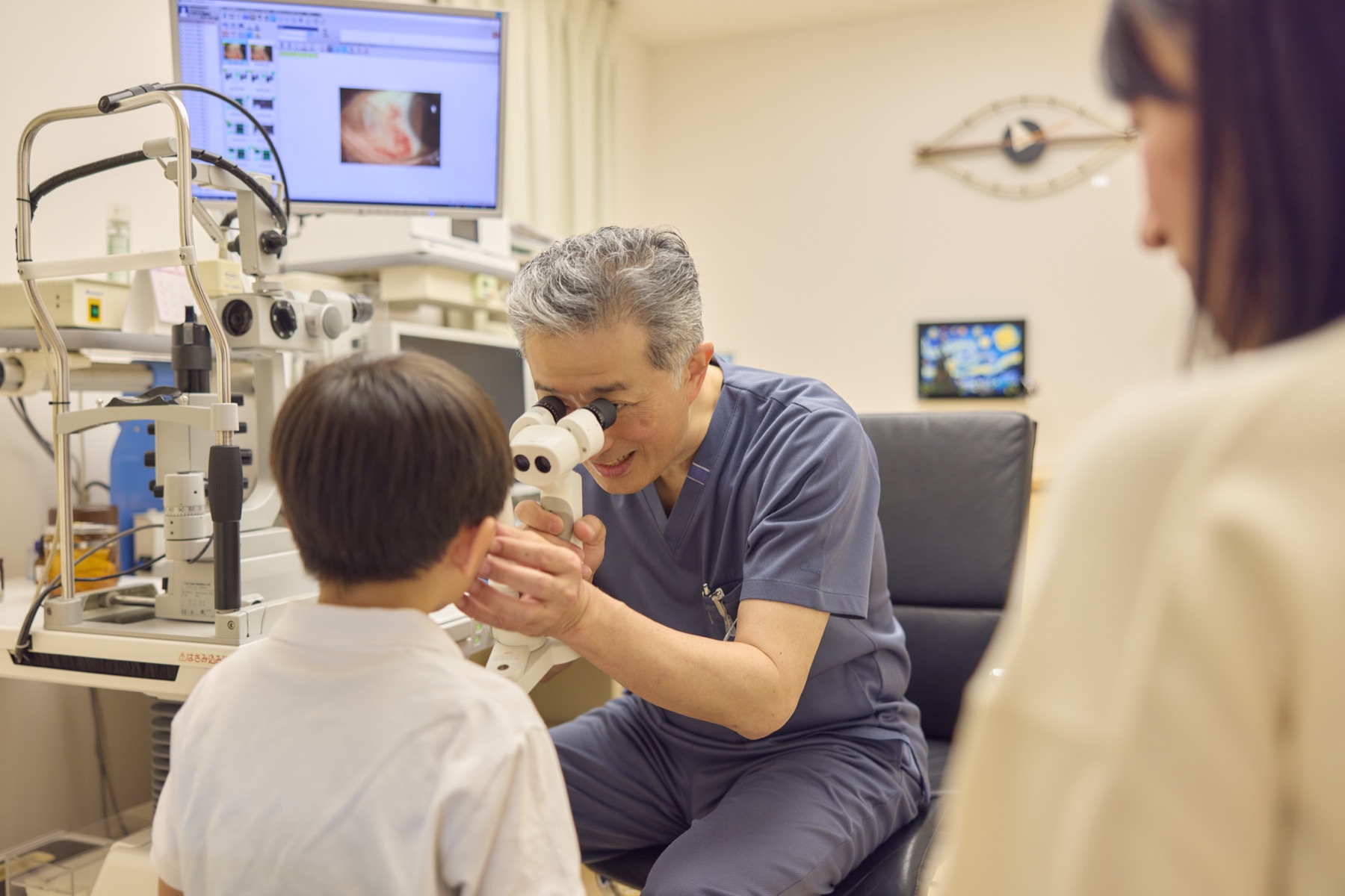 保護者が見守る中、お子さまの目を診察する院長 山㟢 圭