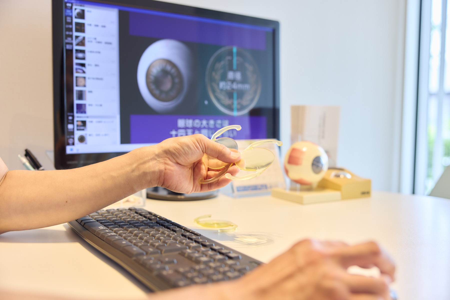 手に持った眼内レンズの説明用模型